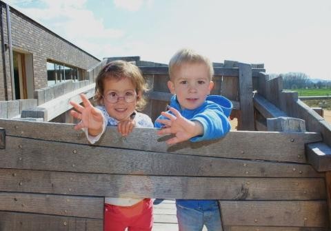 Zwei Kita-Kinder winken auf der Dachterrasse