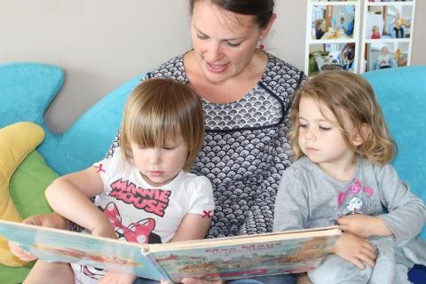 Zwei Kinder lauschen konzentriert beim Vorlesen der KiTa